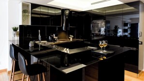 A modern kitchen with a central island, black cabinetry, and a skylight. - Great Apartments in Prime North Location (Bucharest)