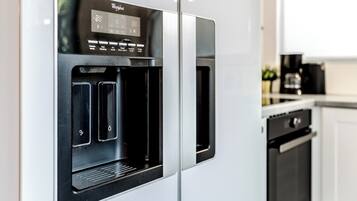 A modern kitchen with a built-in water dispenser, a coffee maker, and a dishwasher.