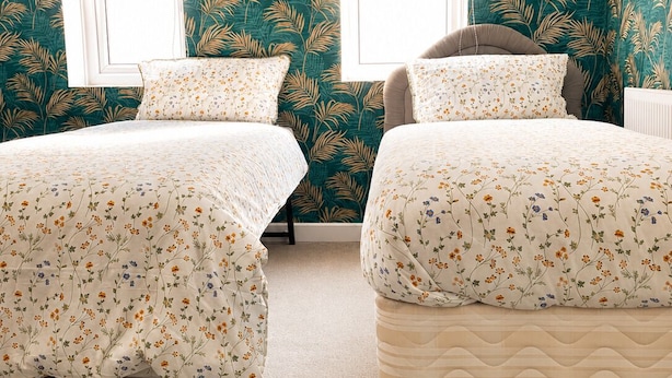 A bedroom with two beds, a window, and a wall with a leafy pattern. - Room-twin Single Bedroom Perfect for con (Wolverhampton)