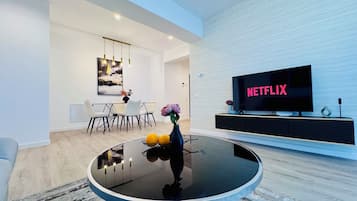 Apartamento luxo, 2 quartos, para não fumantes | Área de estar | Smart TV 126 cm com canais digitais