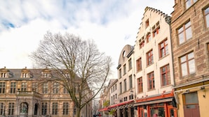 A cobblestone street lined with historic buildings, a statue, and outdoor seating areas. - Stylish Duplex for 6 in Antwerp (Antwerp)