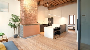 A modern kitchen with a brick fireplace, wooden beams, and a central island. - Stylish Duplex for 6 in Antwerp (Antwerp)