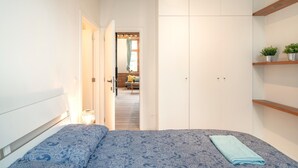 A bedroom with a bed, a wardrobe, and a small shelf with plants. - Stylish Duplex for 6 in Antwerp (Antwerp)