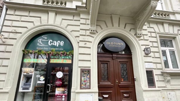 Een gebouw met een café en appartementenhotel in een oude stad.