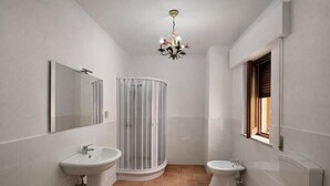 A bathroom with a shower, two sinks, a toilet, a mirror, and a chandelier. - BnB Short-term rental Palermo Center, vacation home apartment (Palermo)