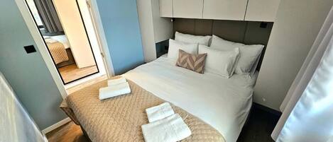 A hotel room with a bed, a mirror, and a wardrobe.