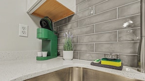 A kitchen with a stainless steel sink, a green appliance, a potted plant, and a countertop with a sponge. - Green & Private 2BR King Bed/Pool/Gym Near UAB/Hospitals (Homewood)
