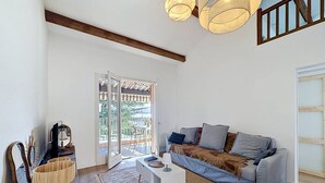 A living room with a sofa, a coffee table, a mirror, and a wooden floor. - Apartment near beach with parking - 4 guests (Saint-Cyr-sur-Mer)