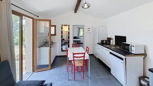 Una cucina compatta con zona pranzo, lavello e frigorifero.