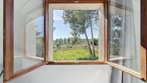 Una stanza con un'ampia finestra che si affaccia su un paesaggio naturale.