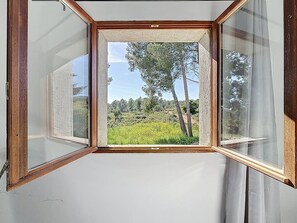 A room with a large window overlooking a natural landscape. - Cottage with air conditioning in quiet - 4 guests (La Cadière-d'Azur)