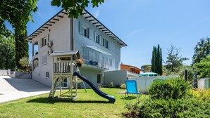 A two-story building with a balcony, a slide, and a patio area with a chair. - Apartment 'Virginia' with Mountain View, Shared Pool and Wi-Fi (Bosco di Piccione)