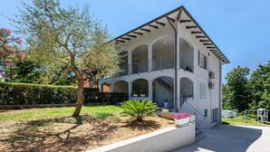 A multi-story building with a balcony, a staircase, and a garden area. - Apartment 'Virginia' with Mountain View, Shared Pool and Wi-Fi (Bosco di Piccione)