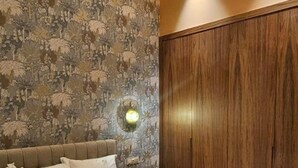 Un dormitorio con cama, mesita de noche y lámpara de pared.