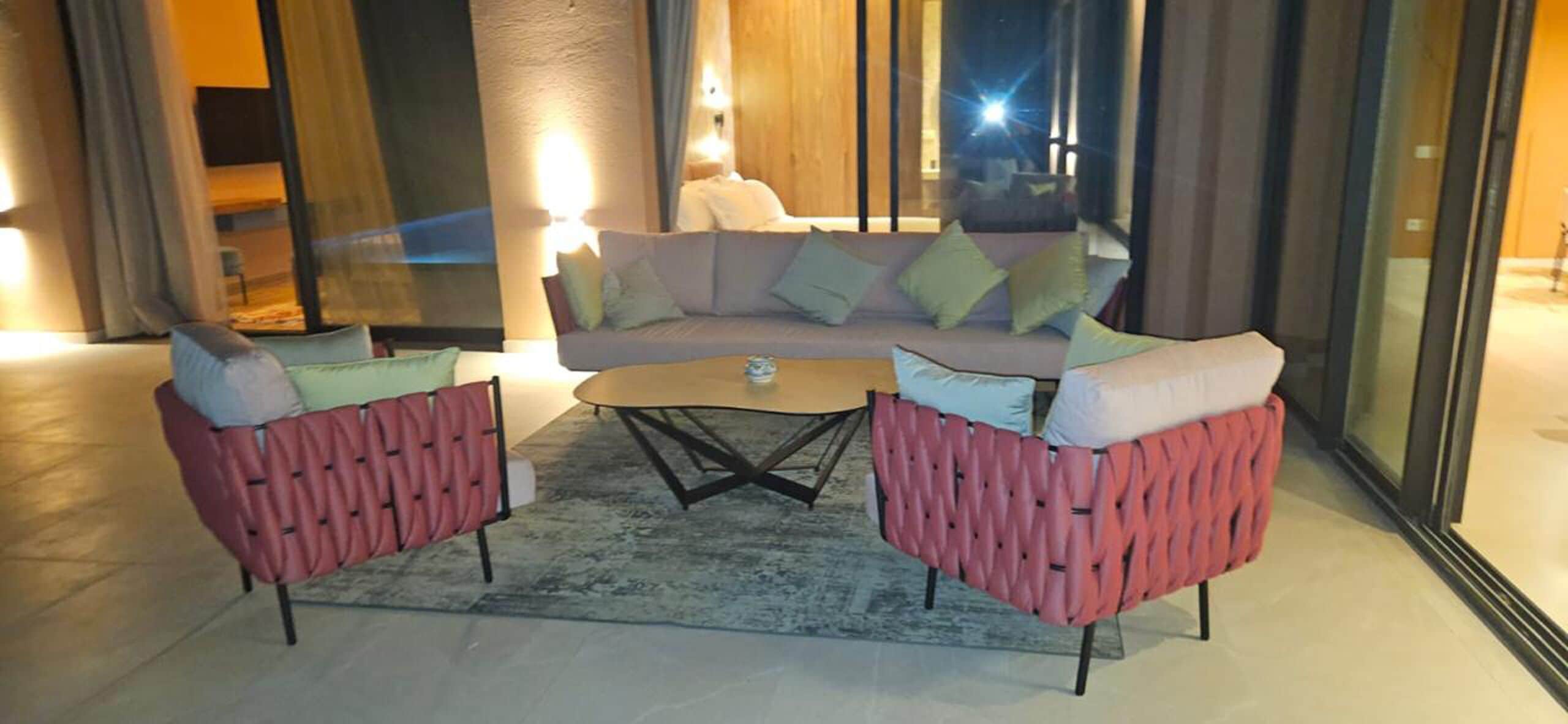 A modern living area with a sofa set, two armchairs, and a coffee table.