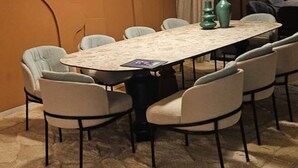 Un salón de conferencias con una mesa redonda, sillas e iluminación colgante.