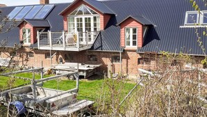 A residential building with a sloped roof, a balcony, and a large window. - 7 Person Holiday Home in Logstrup (Logstrup)