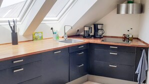 A modern kitchen with skylights, a coffee maker, and a stainless steel range hood. - 7 Person Holiday Home in Logstrup (Logstrup)