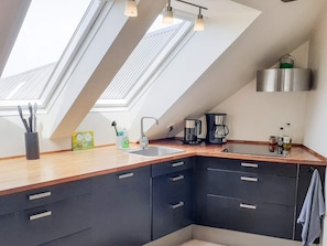 A modern kitchen with skylights, a coffee maker, and a stainless steel range hood. - 7 Person Holiday Home in Logstrup (Logstrup)