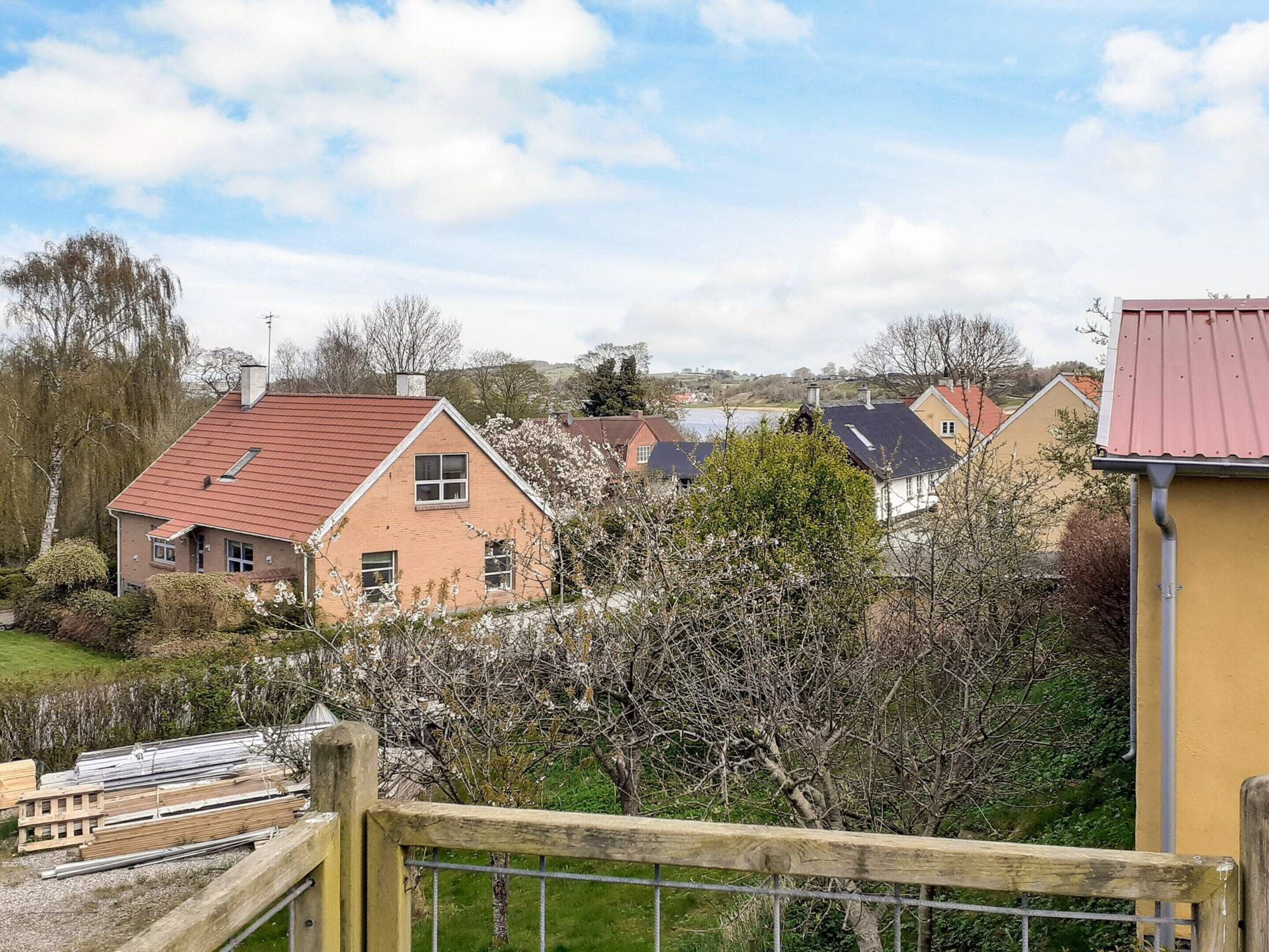 Un quartier résidentiel avec des maisons, une clôture en bois et un ciel dégagé.