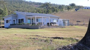 A single-story house with a flat roof, a covered porch, and a landscaped front yard.