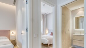 A hotel room with a bed, a bathroom with a mirror, and a shower area. - Modern apartment near the marina - Estepona (Estepona)