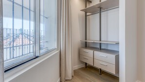 Huoneessa on ikkuna, puulattia, sisäänrakennettu vaatekaappi laatikoineen sekä hyllykkö.