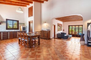 A spacious kitchen with wooden cabinets, a dining table, and chairs. There is a large window providing natural light. - SON SERRA DE DALT 6 people privat pool wifi Felanitx (Felanitx)