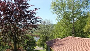 A house with a red roof, surrounded by greenery and trees.