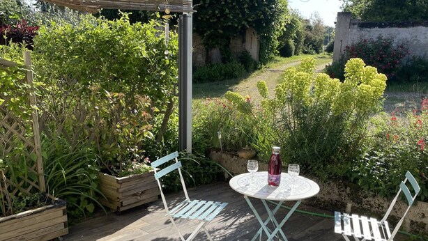 An outdoor patio with a round table, two chairs, a bottle, and glasses. - Peaceful cottage, parking, pets allowed (Saint-Georges-sur-Cher)