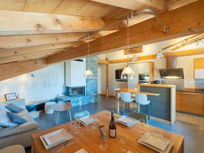 A modern kitchen with a stone backsplash, wooden beams, and pendant lighting. - Spacious apartment with Wi-Fi - 6 guests (Les Gets)