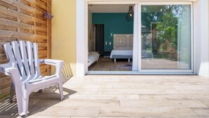 A room with a bed, a chair, and a sliding glass door leading to an outdoor area. - 5-star villa, heated pool, 4 rooms with private baths and BBQ - Up to 12 guests (Parentis-en-Born)