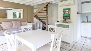 A modern interior with a dining area, kitchen, and staircase. - Biscarrosse: Duplex with Garden, 6 Pers. and Private Parking (Biscarrosse)