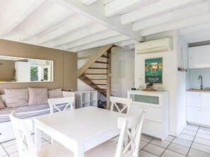 A modern interior with a dining area, kitchen, and staircase. - Biscarrosse: Duplex with Garden, 6 Pers. and Private Parking (Biscarrosse)