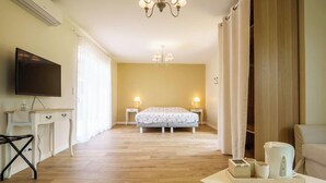 A hotel room with a bed, bedside lamps, a TV, a desk, and a coffee table. - 5-Star Villa: Heated Pool, 24 people, near Parentis-en-Born lake (Parentis-en-Born)