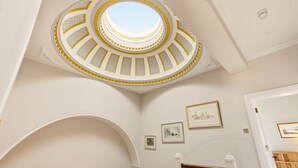 Eine prachtvolle Treppe mit einem runden Oberlicht und Blick zum Himmel.
