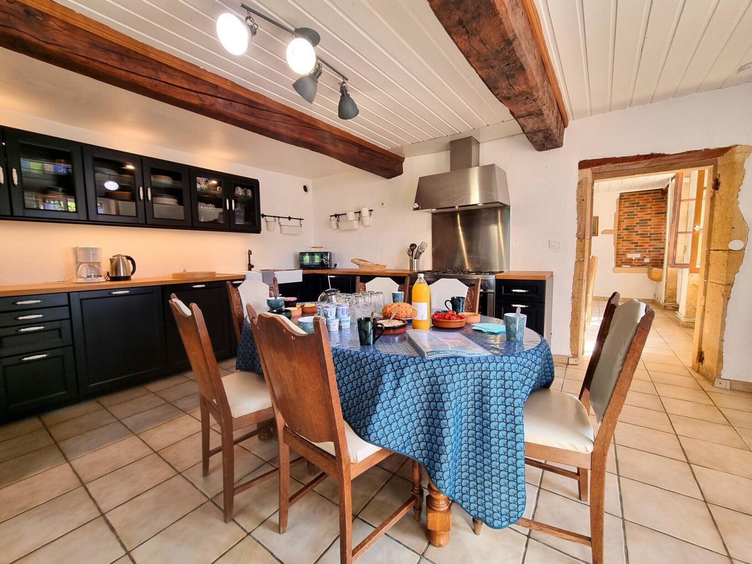 Une cuisine avec une table à manger, des chaises et un téléviseur.