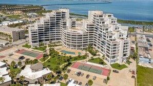 Un hôtel moderne, doté de plusieurs étages, d’une piscine et offrant une vue sur la mer.