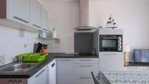A compact kitchen with a microwave, oven, and sink. - Biscarrosse Beach - T2 steps from the beach, private parking (Biscarrosse)