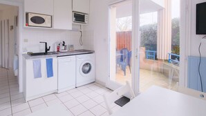 A compact kitchen with a washing machine, a microwave, and a coffee maker. - Biscarrosse Beach Apt Terrace 4 pax with Parking (Biscarrosse)