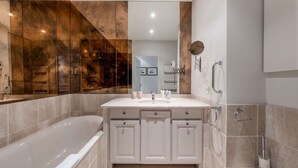 A modern bathroom with a bathtub, a vanity with a mirror, and a toilet. - Charming apartment in resort centre - 6 guests (Courchevel 1550)