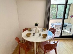 Ein runder Esstisch mit sechs Stühlen, eine weiße Vase mit Pflanze sowie verschiedene Schalen und Gläser darauf.