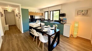 A compact kitchen with a dining area, wooden flooring, and a small refrigerator. - Air-conditioned apartment near beach - 6 guests (Six-Fours-les-Plages)