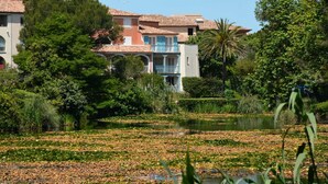 A residential area with a water body, trees, and buildings with balconies. - Air-conditioned apartment near beach - 6 guests (Six-Fours-les-Plages)
