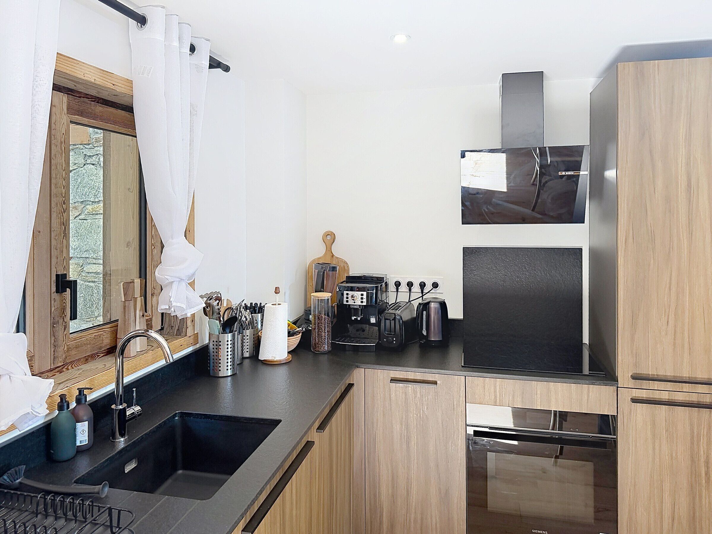 A modern kitchen with a sink, stove, and various appliances.