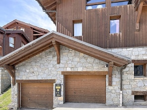 A multi-story building with stone walls and wooden balconies. - Apartment with mountain view - 12 guests (Montvalezan-La Rosière)