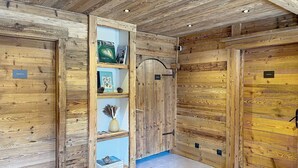 A wooden interior with a bookshelf, a door labeled 'TERRE,' and a blue wall. - Spacious apartment, Mont Pourri view - 8 guests (Montvalezan-La Rosière)