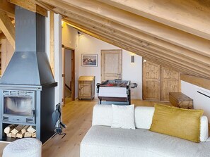 Ein gemütliches Schlafzimmer im Loft-Stil mit Kaminofen, einem Kicker und einer hohen Decke.