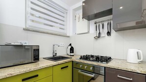A modern kitchen with a microwave, sink, stove, and cabinets.