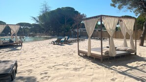 A beach with sunbeds and a canopy bed. - La Tamarissière Village  (Agde)